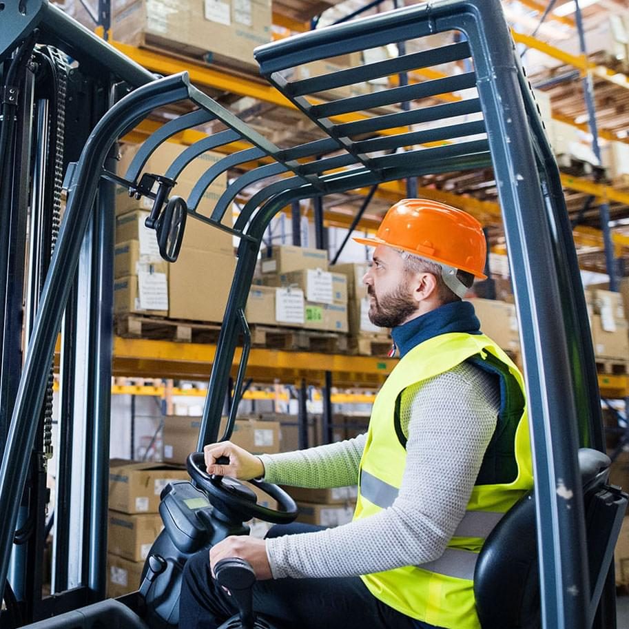 Man forklift driver working in a warehouse using motive power.